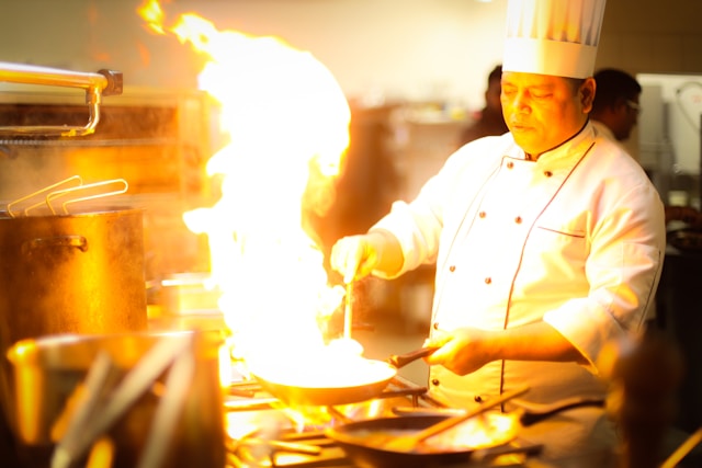 料理をするシェフのイメージ。フランベをしているシェフ。